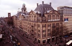 Torentje boven de hoofdingang van de Amsterdamse Bijenkorf (midden). Links het torentje op de Beurs van Berlage