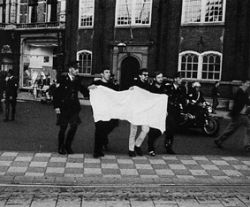 Omdat alle demonstraties verboden worden wegens 'opruiende' leuzen, demonstreren provo's op het Spui met een blanco spandoek. 
Zij worden onmiddellijk gearresteerd.
